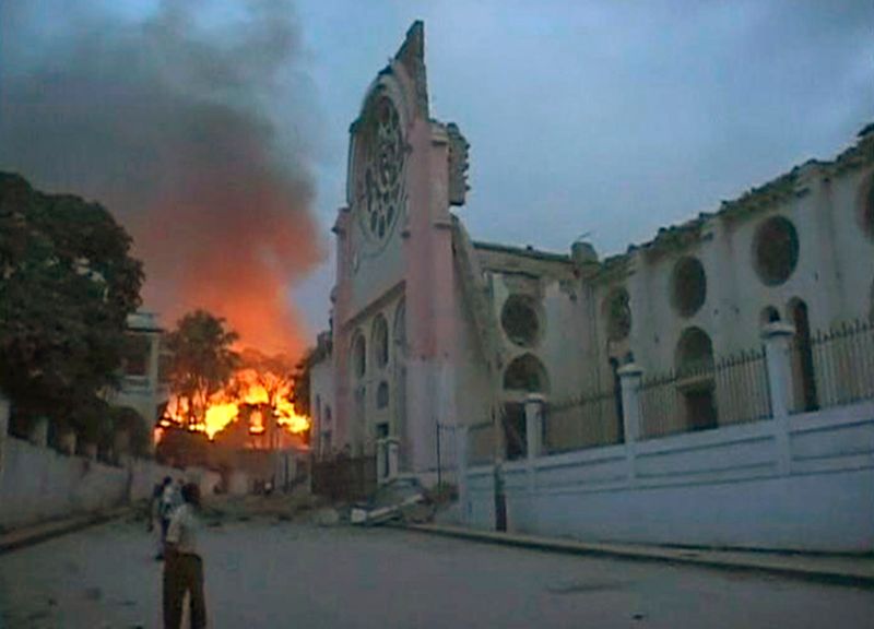 Пожар разгорелся недалеко от здания, поврежденного сильным землетрясением, в Порт-о-Пренс 12 января.