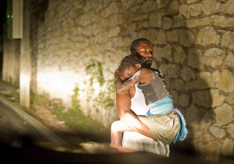 Отец несет дочку после землетрясения в Порт-о-Пренс 12 января.
