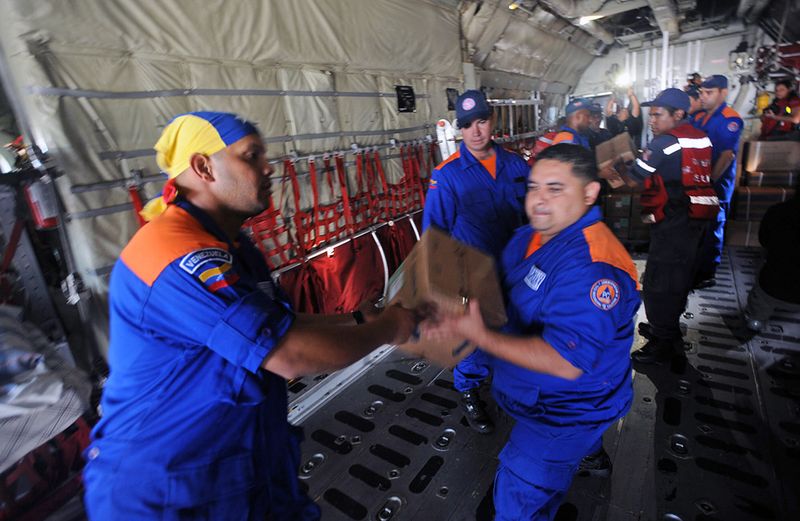 Венесуэльские спасатели грузят медицинское оборудование и лекарства на самолет, направляющийся в Порт-о-Пренс 13 января 2010 года в международном аэропорту «Симон Боливар» в Каракасе