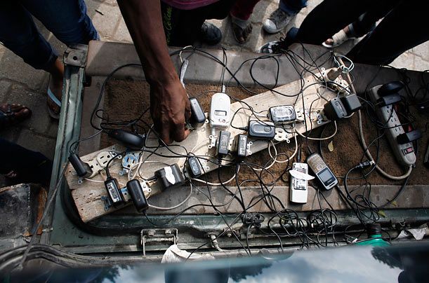Пригород Порт-о-Пренс. Гаити. Пункт проката подключенных к электросети зарядок для мобильников.