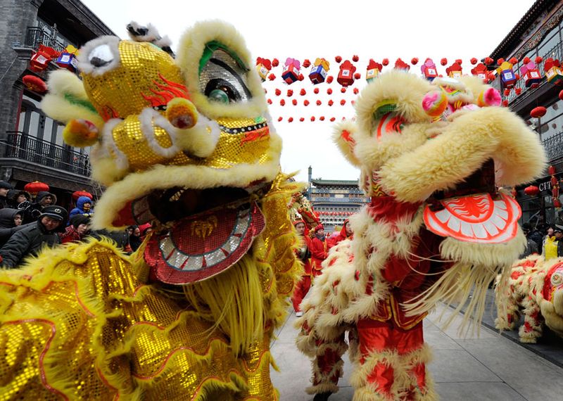 Китайцы исполняют танец льва в первый день Лунного Нового года в районе Пекина Цяньмэнь.