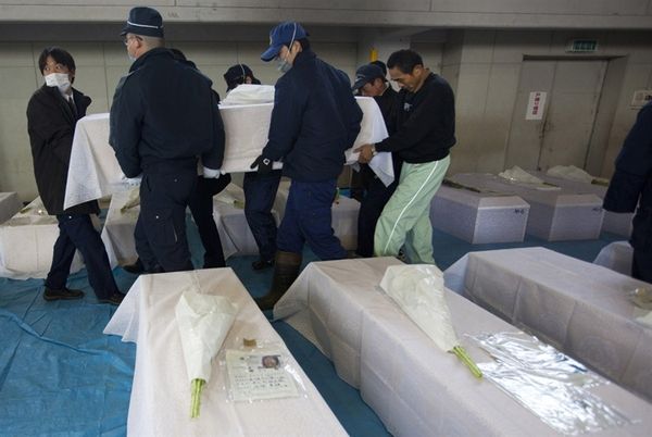 2. Полицейские и родственники несут гроб с телом Масайши Ойама, погибшего во время цунами. Процедура кремации, 24 марта 2011 года, Курихара, Япония.