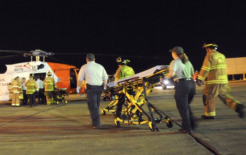 Медики бегут с носилками к спасательному вертолету береговой охраны в Новом Орлеане. Вертолет помог вывезти раненых работников с буровой платформы «Deepwater Horizon», где сегодня произошел пожар. 