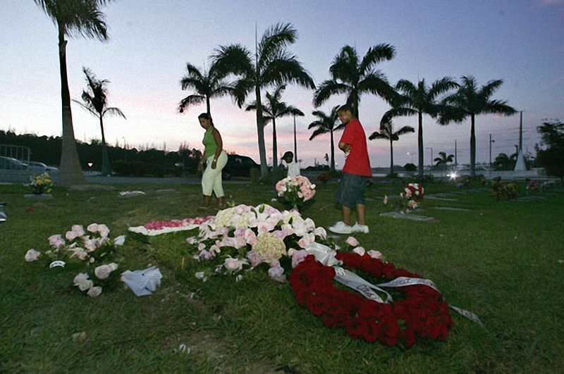  Местные жители у могилы Анны Николь Смит в Нассау на Багамах 2 марта 2007 года. Бывшая модель «Playboy» и жена миллиардера была похоронена на Багамах после трех недель судебных разбирательств по поводу ее тела. 