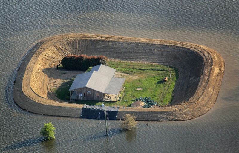 Плотина защищает дом от паводковых вод реки Язу недалеко от Виксбурга, штат Миссисипи. Из-за наводнения в Миссисипи река Язу вышла из берегов в месте их слияния, недалеко от города Виксбург, затопив города и фермы вверх по течению. (Scott Olson/Getty Images)