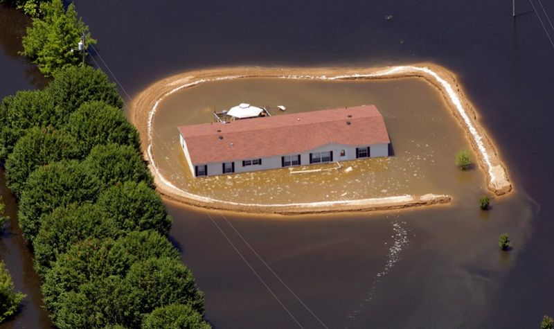 Затопленный дом, окруженный осыпавшейся плотиной, в Виксбурге. (AP Photo/Dave Martin)