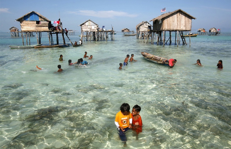 Маленькие морские цыгане играют в воде среди домов в море Сулавеси, 17 февраля 2009. (REUTERS/Bazuki Muhammad (MALAYSIA)