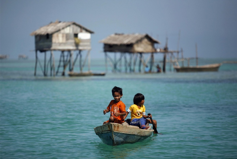 Мальчики из племени морских цыган гребут на лодке неподалеку от своего дома в море Сулавеси в малазийском штате Сабах на Борнео. Снимок сделан 17 февраля 2009. (REUTERS/Bazuki Muhammad)