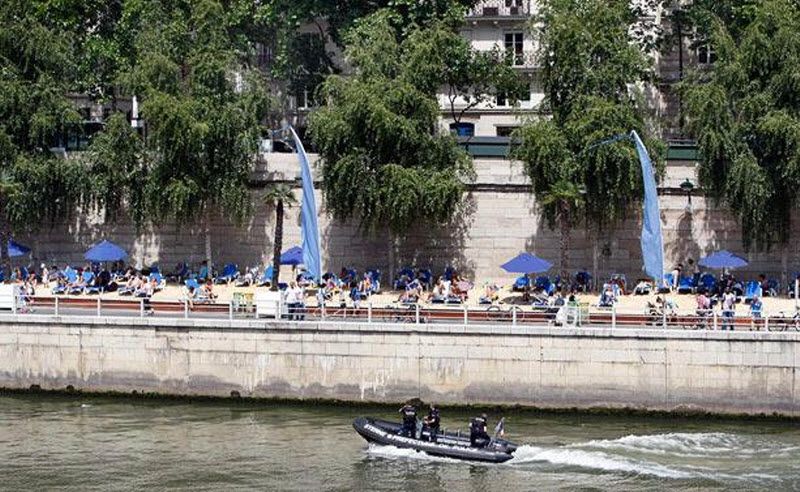 6. Полицейский катер проплывает мимо искусственных пляжей на правом берегу реки Сена. (AP)
