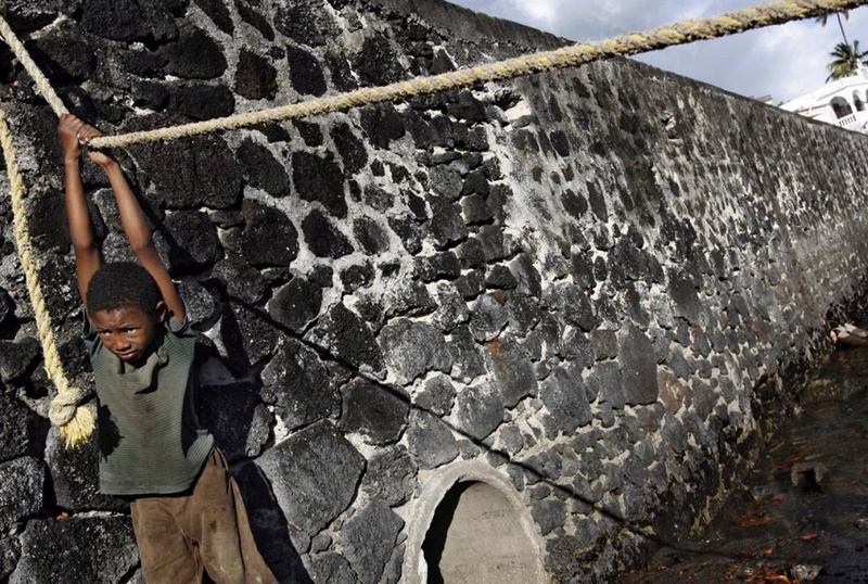 Мальчик висит на веревке в старом порту Морони на одном из Коморских островов 3 июля. Коморские острова получили независимость от Франции в 1975 году. С тех пор здесь происходило более 20 государственных переворотов.