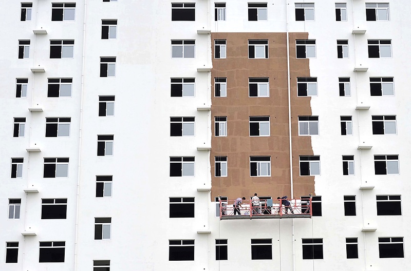 Рабочие красят фасад жилого дома в китайском городе Сянфань, Хубэй, четверг. Китай в скором времени разрешит запуск инвестиционных фондов недвижимости на межбанковском рынке, что даст девелоперам больше вариантов выхода из кризиса и расширения каналов для китайских инвесторов. (Reuters)