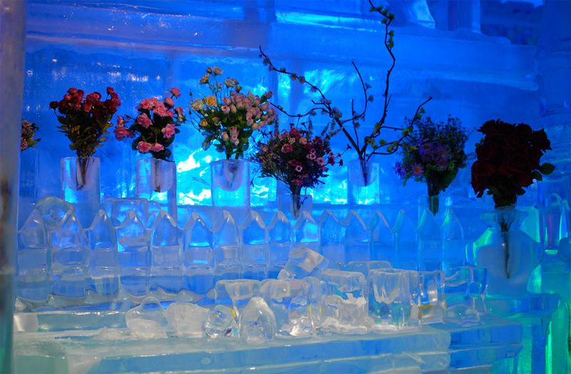 Живые цветы стоят в ледяных вазах.