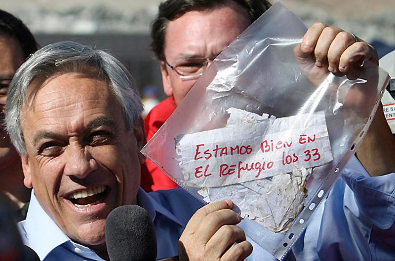 Чилийский президент Себастьян Пинера держит записку от шахтеров с надписью «Мы в порядке – все 33». 18 сентября Чили  отпразднует двухсотлетие своей независимости. Пиньера уже посчитал чудесное известие “добрым предзнаменованием” на следующие 200 лет. (Hector Retamal / AP)