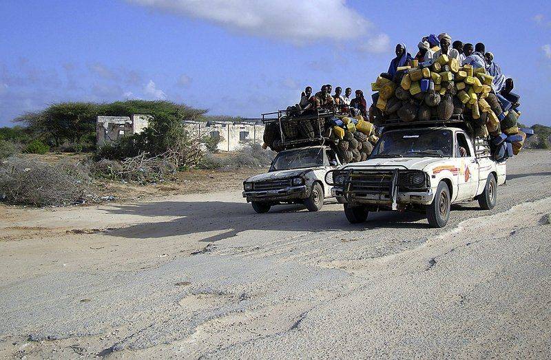 Местные жители едут на пикапах, которые перевозят молоко и другие товары в Могадишо, Сомали.