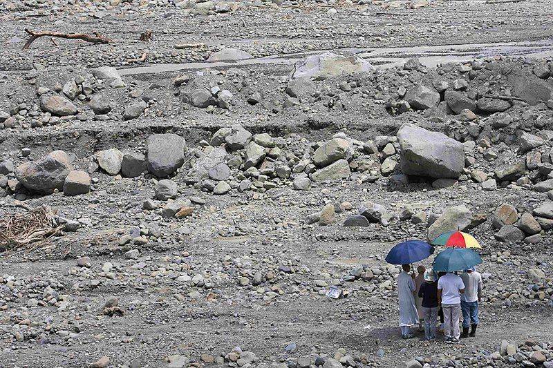 Люди стоят во время минуты молчания в память о жертвах оползня в тайваньской деревне Hsiaolin, в то время как Далай-лама, (не видно на фото), молится за жертв тайфуна «Моракот» понедельник. Духовный лидер Тибета в изгнании посетил Тайвань, опустошенный наводнением, с гуманитарным визитом. Китай осудил этот визит.