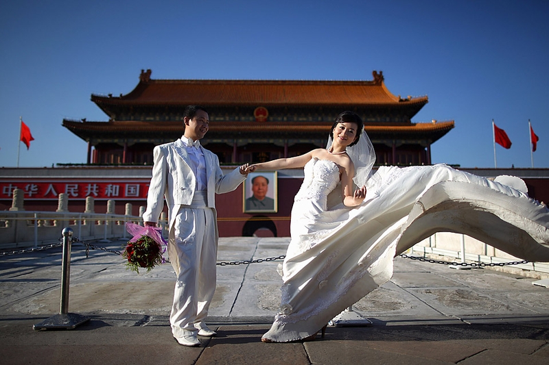 Новобрачные фотографируются перед воротами Тяньаньмэнь в Пекине