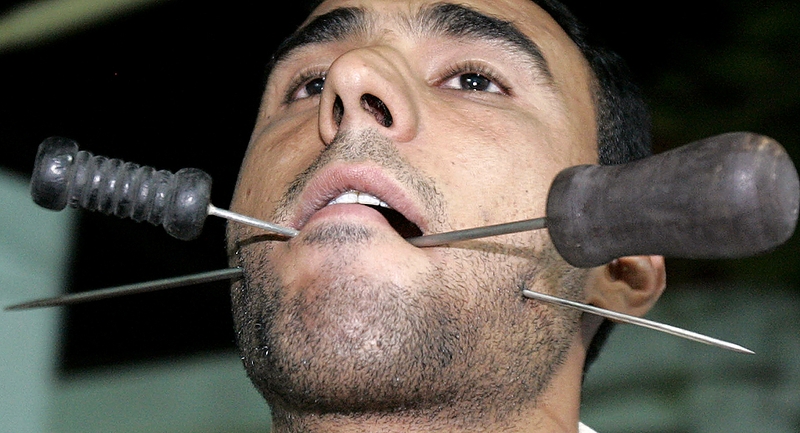 Человек пронзил свои щеки, чтобы показать силу своей веры в последние дни священного для мусульман месяца Рамадан в Басре, Ирак