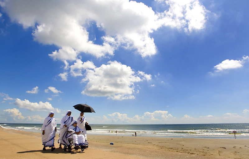 Группа сестер из Калькуттской миссионерской службы Матери Терезы гуляют по пляжу в городе Галвестон, штат Техас.