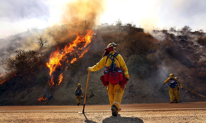 Пожарный Крис Гэннон, в центре, наблюдает за контролируемым поджогом, который совершила его команда, чтобы выжечь кустарники недалеко от Пиру, Калифорния.