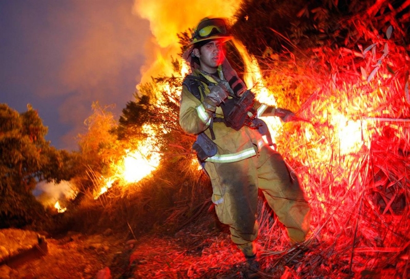 Пожарный Эстебан Вирадо поджигает кустарник, чтобы вызвать контролируемое горение во время пожара на Ранчо Кроуфорда, недалеко от Граймс Каньона в Фильморе, штат Калифорния, 22 сентября. В пожарах на юге Калифорнии этим летом сгорело множество домов.