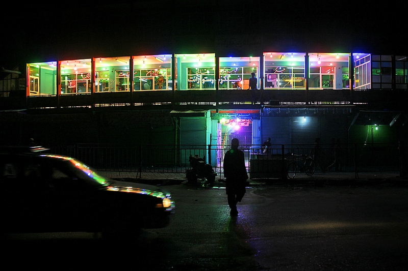 Человек проходит мимо ярко освещенного ресторана в Кабуле.