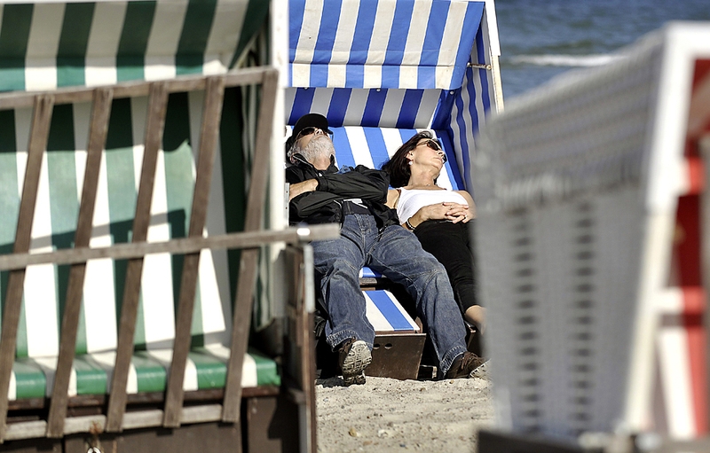 Мужчина с женщиной отдыхают в шезлонге на балтийском морском курорте в Варнемюнде, Германия.