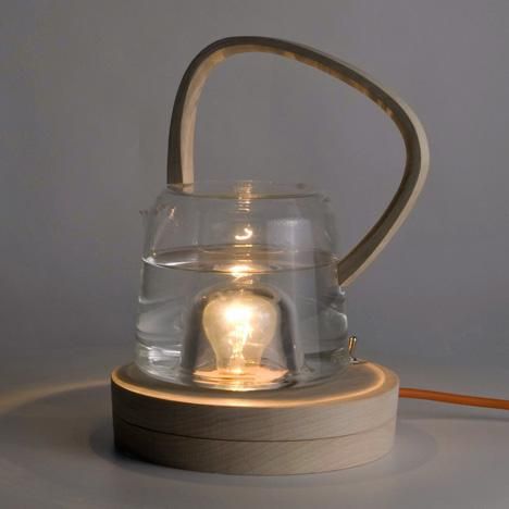 Лампа накаливания установлена на деревянной подставке, а стеклянный кувшин с водой близко к лампе, но не касаясь ее.