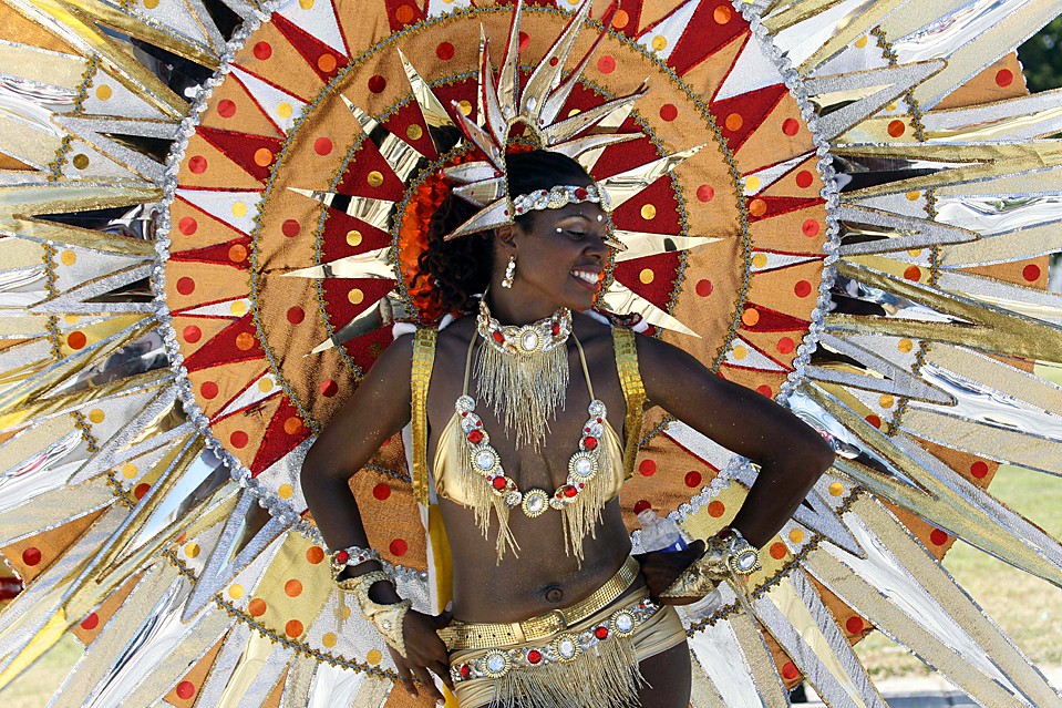 Гайель Феликс – танцовщица труппы «Веселое поколение» - демонстрирует свой костюм на параде Майями-Бровард, олицетворяющем карибскую культуру, в Майями.