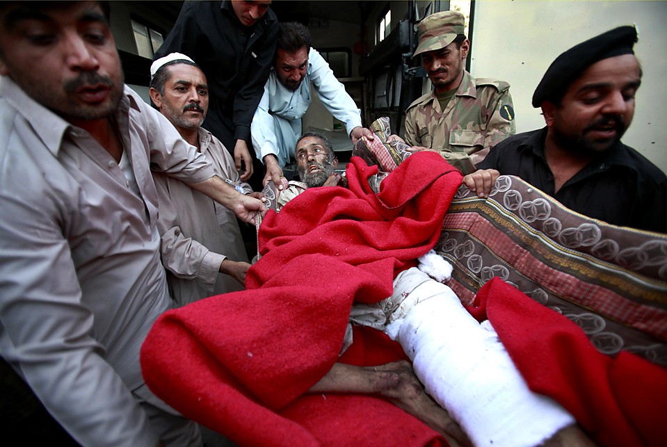 Раненого мужчину переносят в больницу в Пешаваре, Пакистан, в понедельник. Рядом с военным автомобилем на рынке в округе Шангла взорвался автомобиль террористов-смертников. В результате погиб 41 человек, включая 6 офицеров службы безопасности, а еще 45 получили ранения.