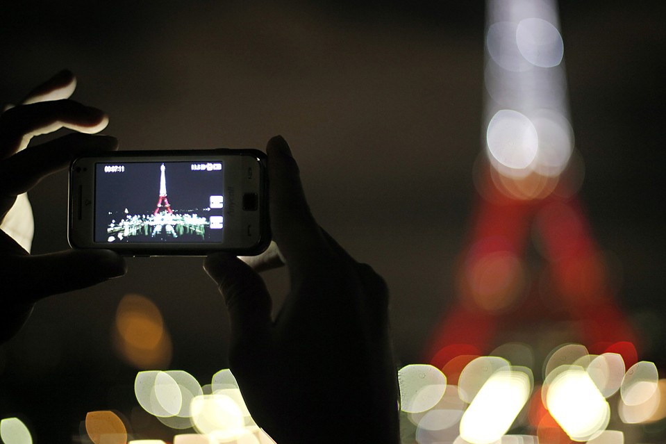 Турист фотографирует Эйфелеву башню в Париже, Франция