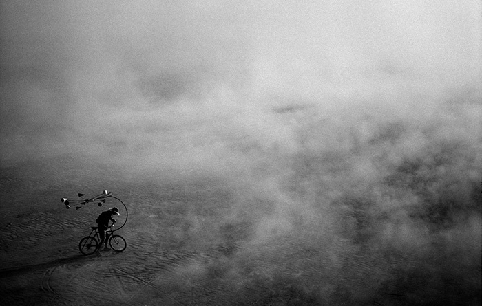 Передвигаться по пустыне удобнее на велосипеде. На снимке момент, когда в налетевшем песчанном шквале, человек пытается покинуть площадь скрыться от бури.