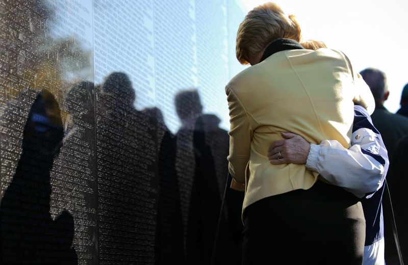 Посетители успокаивают друг друга перед мемориалом жертв Вьетнамской войны в Вашингтоне.