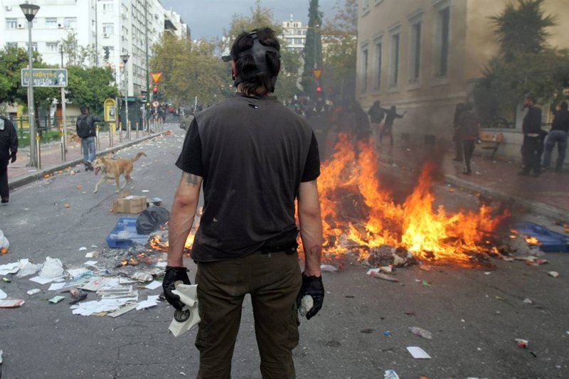 Греческая молодежь била стекла, переворачивала мусорные баки и поджигала мусор.Для разгона многотысячной демонстрации полиция применила слезоточивый газ.