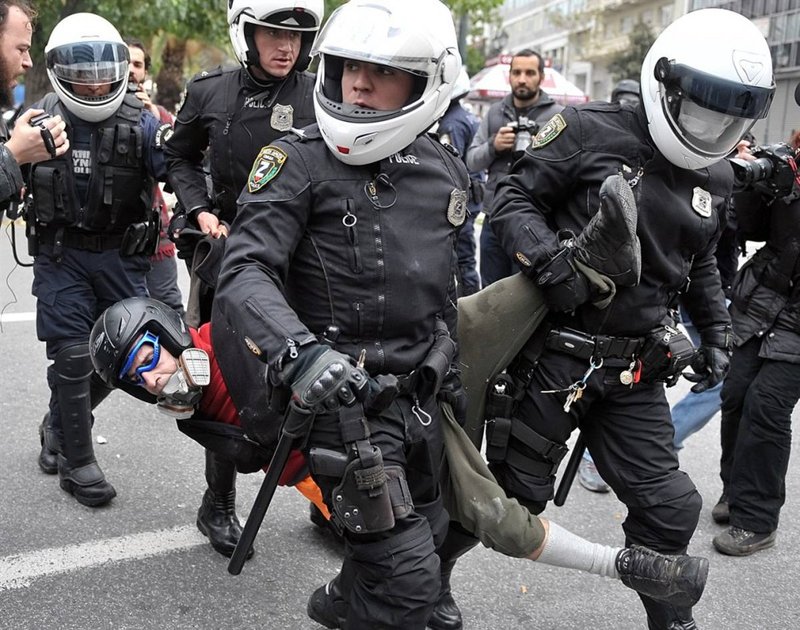 Полиция волочит одного из задержанных демонстрантов в центре Афин.