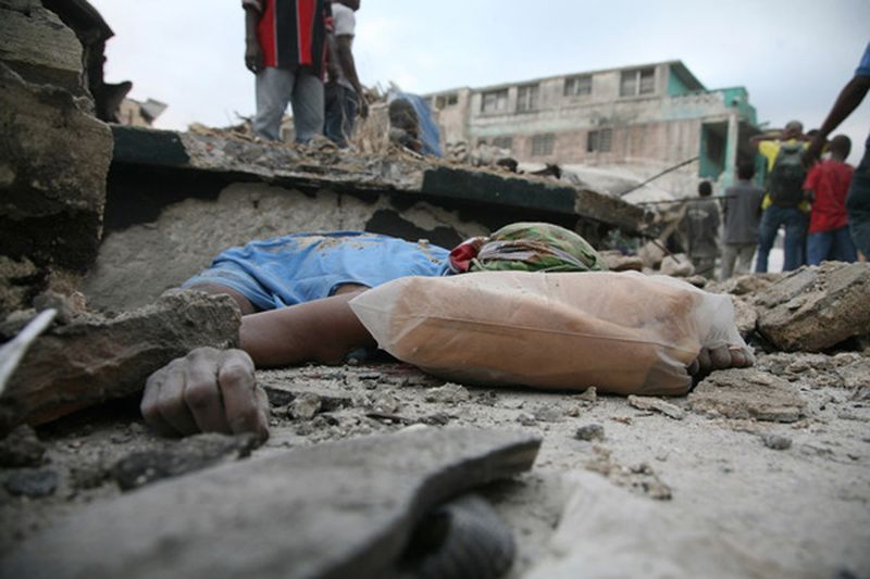 Тело лежит среди обломков 12 января 2010 года в Порт-о-Пренс после землетрясения. 