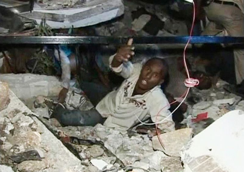 Мужчина зовет на помощь, застряв под обломками здания университета в Порт-о-Пренс 12 января.