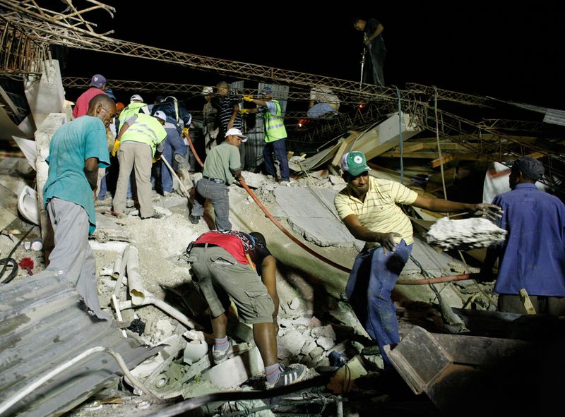 Жители ищут жертв землетрясения в Порт-о-Пренс 12 января.