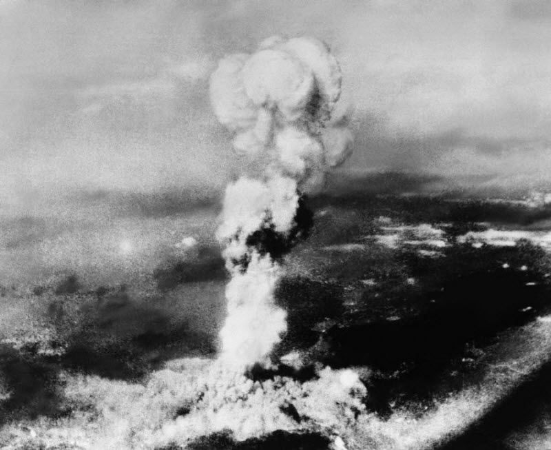  На этой фотографии, сделанной 6 августа 1945 года из города Йошиура, находящегося по другую сторону гор к северу от Хиросимы, виден дым, поднимающийся после взрыва атомной бомбы в Хиросиме. Снимок был сделан австралийским инженером из Куре, Япония. Пятна, оставленные на негативе радиацией, почти уничтожили снимок.