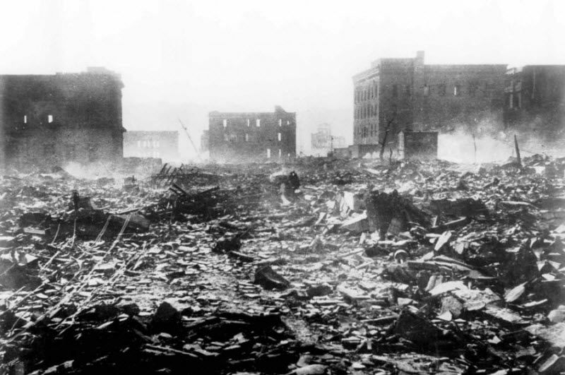 7 августа 1945 года, на следующий день после взрыва атомной бомбы, дым стелется над развалинами в Хиросиме, Япония.