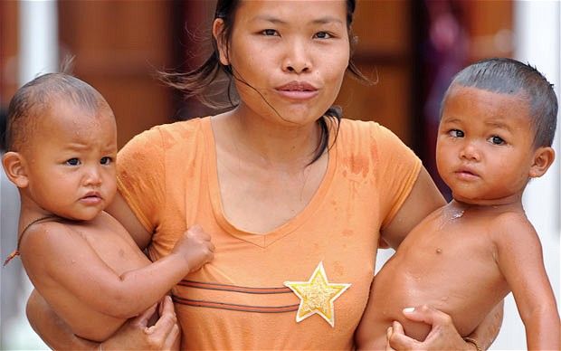  Тайская женщина с двумя детьми во временном лагере после эвакуации. Ее роднйо поселок в провинции Сурин на границе Таиланда и Камбоджи стал ареной боевых действий во время противостояния тайских и камбоджийских войск.