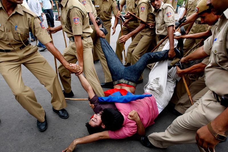 Полиция оттаскивает сторонников Коммунистической партии в Индии во время акции протеста в Нью-Дели. Движение транспорта было приостановлено, а многие предприятия закрылись из-за забастовки против повышения цен на топливо, организованной главными оппозиционными партиями. (AP Photo/Mustafa Quraishi)