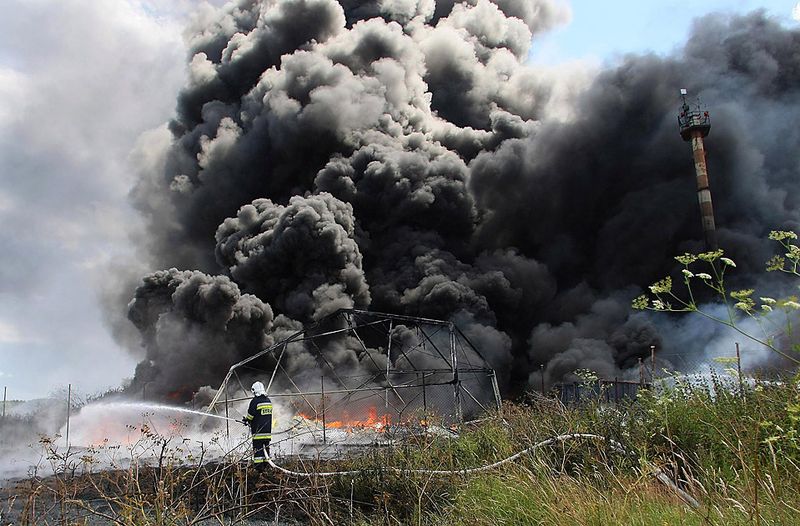 Пожарный помогает потушить огонь на заводе по производству пенопласта в польском городе Велтын. (Jerzy Undro/European Pressphoto Agency)