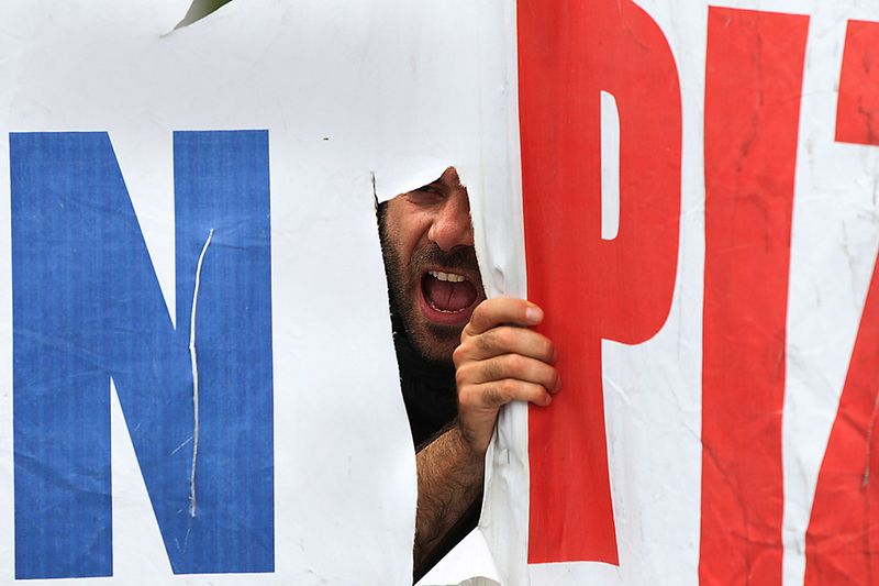 Демонстрант выкрикивает слоганы во время митинга в центре Афин. Более 12 000 человек приняли участие в двух акциях протестов. Социалисты борются за свои права в разгар новой волны протестов против экономических мер. (Thanassis Stavrakis/Associated Press)