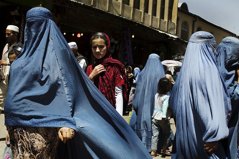 Женщины идут по рынку в центре Кабула мимо точки где продаются детские чемоданы для девочек. (Rodrigo Abd/Associated Press)