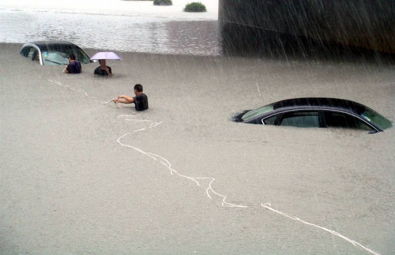 6) Спасатели пытаются вытащить на мель автомобили во время паводка в Вэньчжоу, китайская провинция Чжэцзян 9 августа, после того, как тайфун Моракот прошелся по восточному побережью Китая. В материковой части Китая тайфун стал причиной нескольких смертей, а большинство жертв стихии зарегистрировано в соседнем Тайване. (China Daily/Reuters)