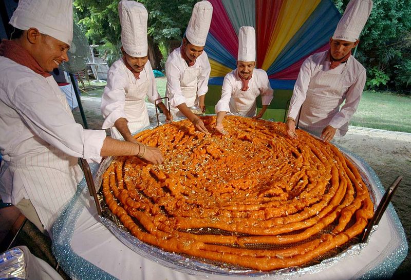 30) Индийские повара придают последние штрихи огромному джалеби – индийской сладости диаметром 1,65 м и весом 26,99 кг – перед фестивалем «Ракша Бандхан» в Ахмадабаде, Индия, 3 августа. (Ajit Solanki, AP)