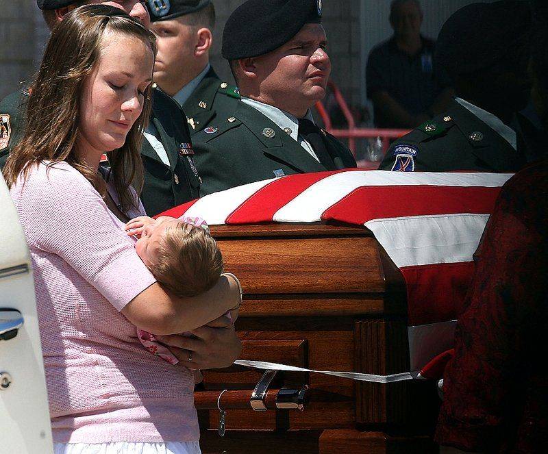 Брук Дженкинс держит свою 10-недельную дочь, Рейган, в то время как гроб с телом ее мужа, капитана армии Кори Дженкинса провозят в аэропорту Феникс-Меса Гейтвей в городе Меса, штат Аризона. Капитан Дженкинс был убит в Афганистане от взрыва самодельного взрывного устройства 25 августа