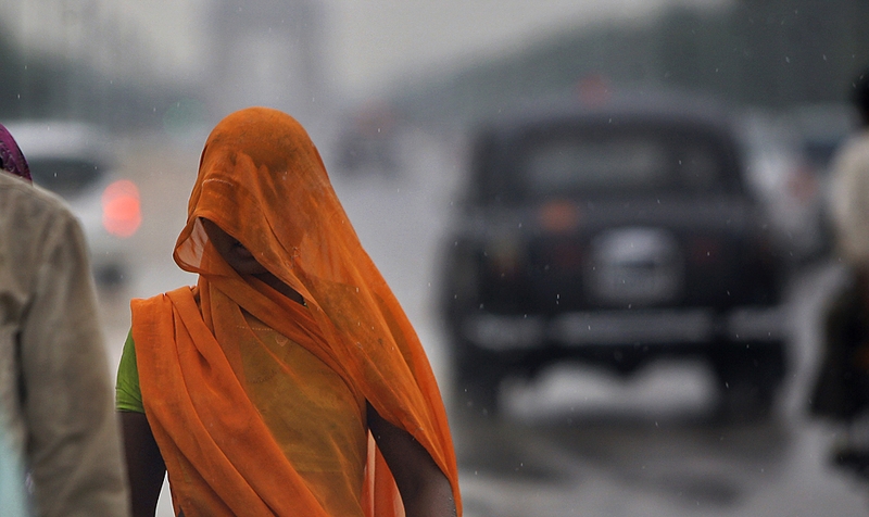 Женщина проходит мимо военного памятника под дождем в Нью-Дели, Индия, в четверг. Сильные ливни обрушились на столицу Индии еще в среду вечером.