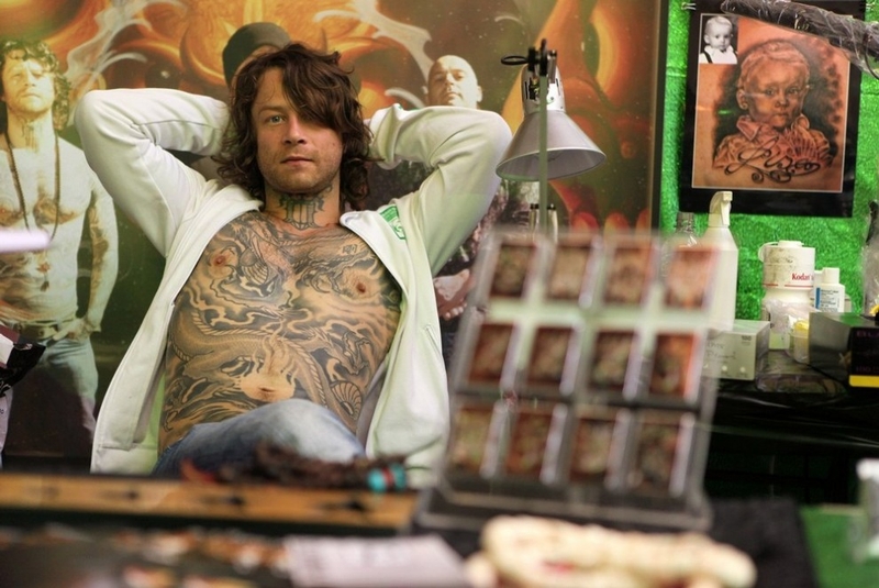 Голландский татуировщик Джероэн Деркс (Jeroen Derks) в ожидании клиентов в день открытия фестиваля тату.