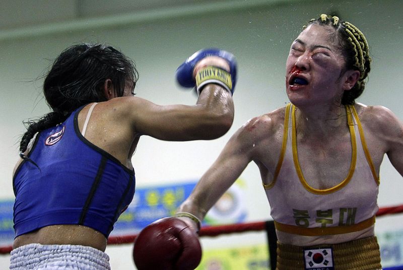Юджет Нагава (слева) бьет Кими Джу-хе в седьмом раунде боксерского поединка в наилегчайшем весе в Аняне, Южная Корея 12 сентября. (AP Photo/Ahn Young-joon)